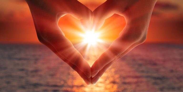 visualizes bliss, photo of hands in heart shape framing ocean sunset