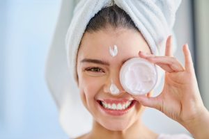 Woman smiling with towel on head, promoting CBD skincare routine